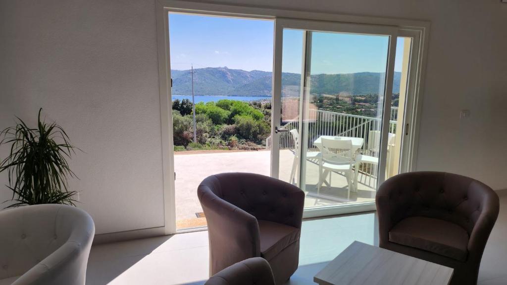 a room with chairs and a view of a balcony at Hotel Borgo Dell'Orso in Palau