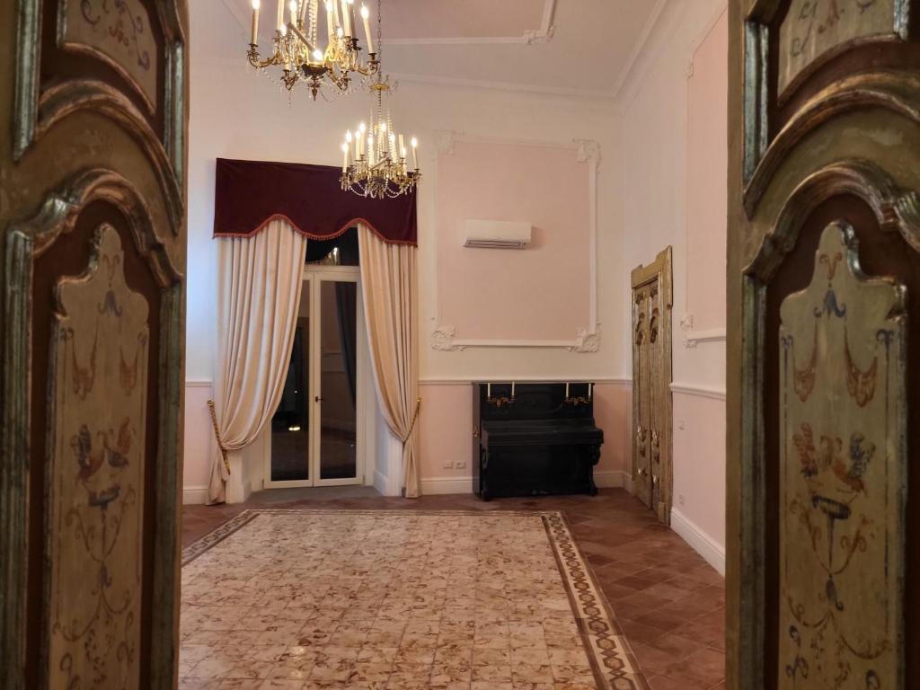 pasillo con puerta, lámpara de araña y habitación en ART HOUSE VENUSIO Naples, en Nápoles