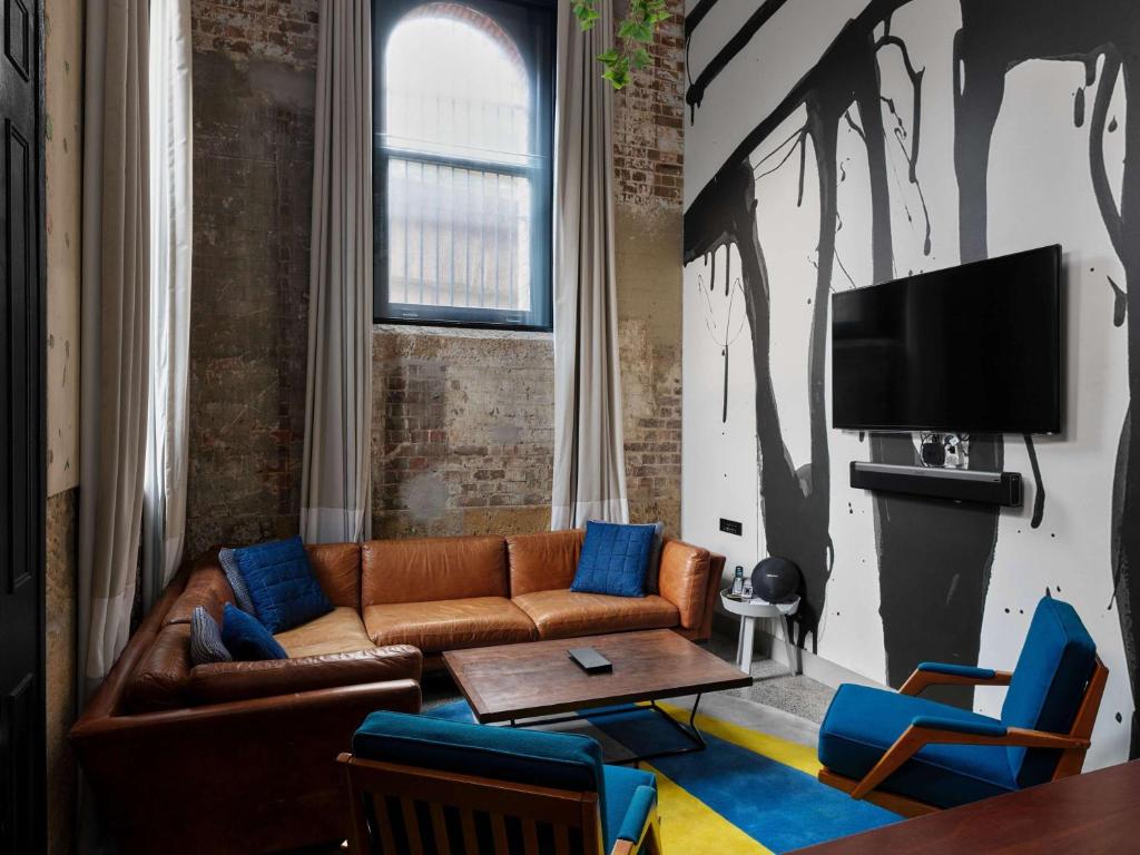 シドニーにあるHotel Woolstore 1888, Sydney - Handwritten Collectionのソファとテレビのあるリビングルーム