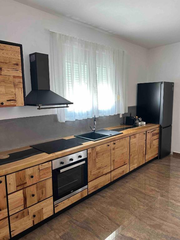 a kitchen with wooden cabinets and a sink and refrigerator at Villa Ellania Milos in Adamantas