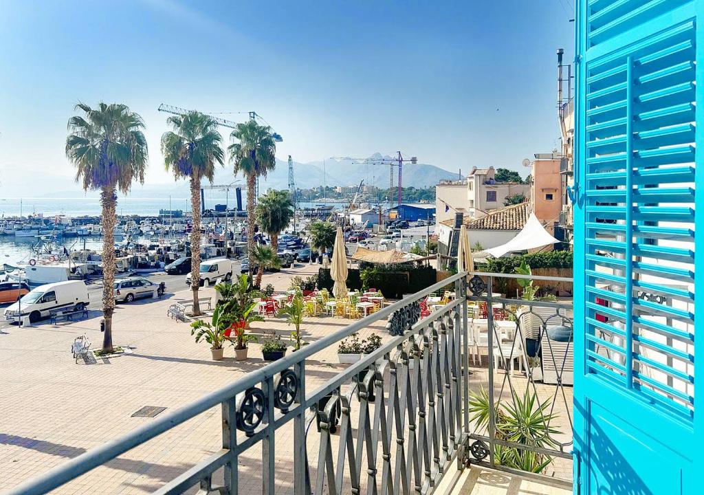 a balcony with a view of a marina and palm trees at Solemar Sicilia - Casa Aura in Porticello