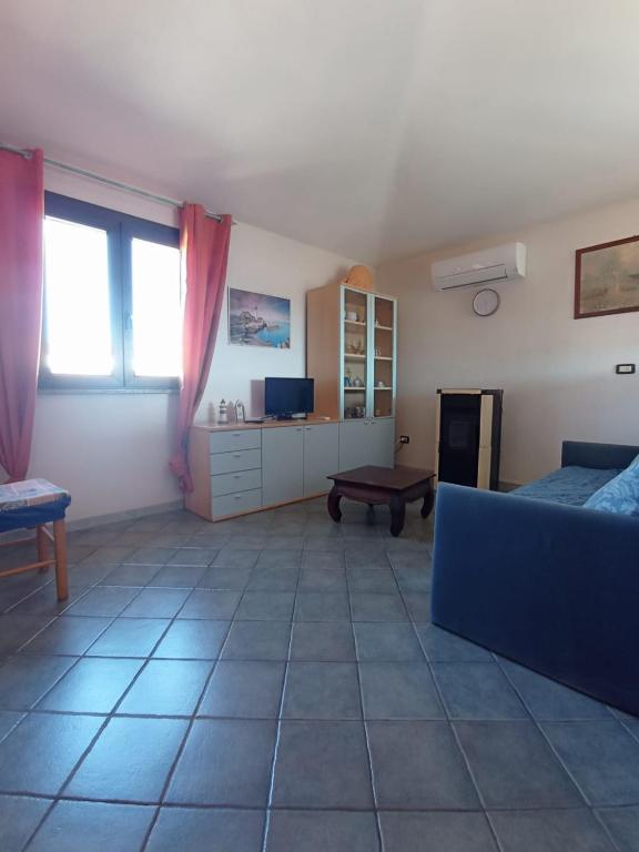 salon z kanapą i stołem w obiekcie Appartamento Sardegna - accogliente e luminoso w mieście Porto San Paolo