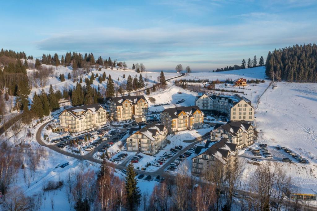 eine Luftaufnahme eines Resorts im Schnee in der Unterkunft Aparthotel Apartamenty Czarna Góra 107 in Heudorf