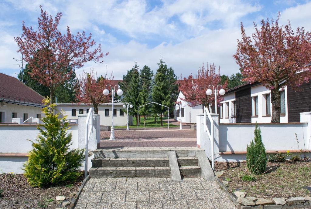a courtyard with a white fence and trees at Hotel Širák in Most