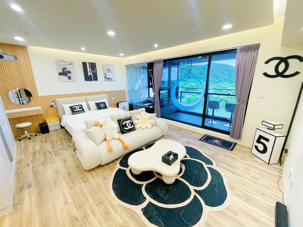 a living room with a white couch and a large window at 光嶼海溫泉海景無邊際泳池豪華套房 in Hsin-hsing