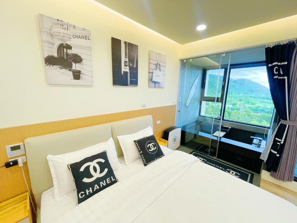 a bedroom with a white bed and a window at 光嶼海溫泉海景無邊際泳池豪華套房 in Hsin-hsing