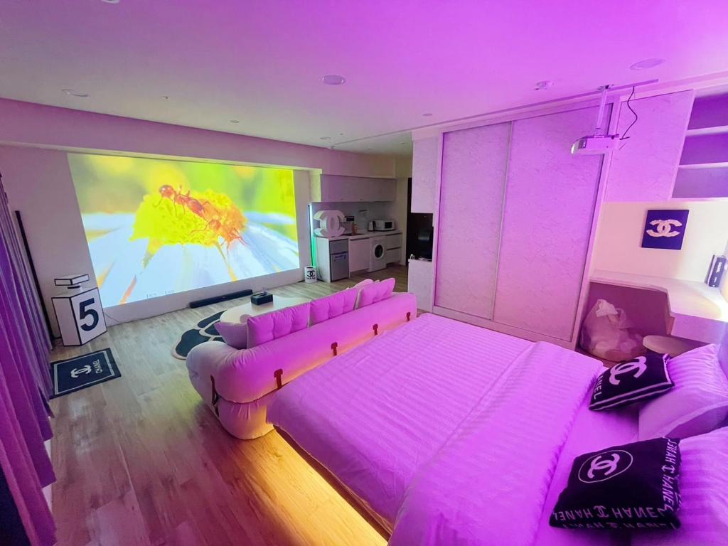 a man is watching a movie on a large screen at 光嶼海溫泉海景無邊際泳池豪華套房 in Hsin-hsing