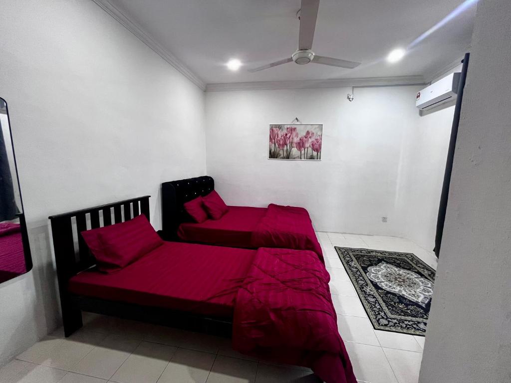 a room with a red bed and a couch at DH Homestay in Sungai Petani