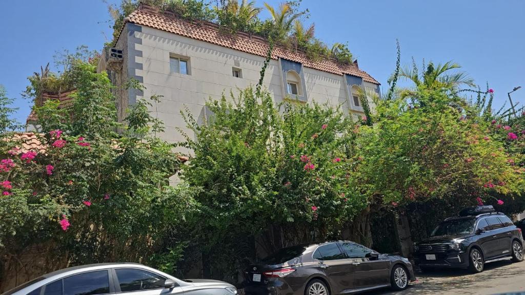 two cars parked in front of a building at شقة استوديو in Abḩur al Janūbīyah
