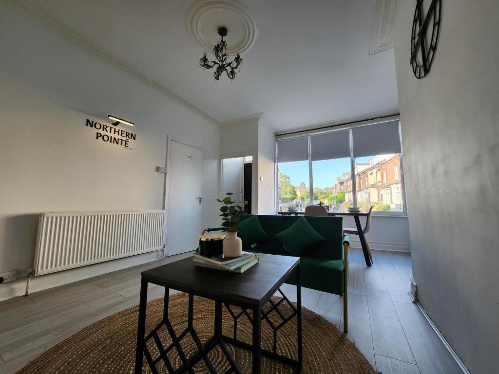 ein Wohnzimmer mit einem Tisch und einem grünen Stuhl in der Unterkunft The Greenhouse near Leeds City Centre in Killingbeck