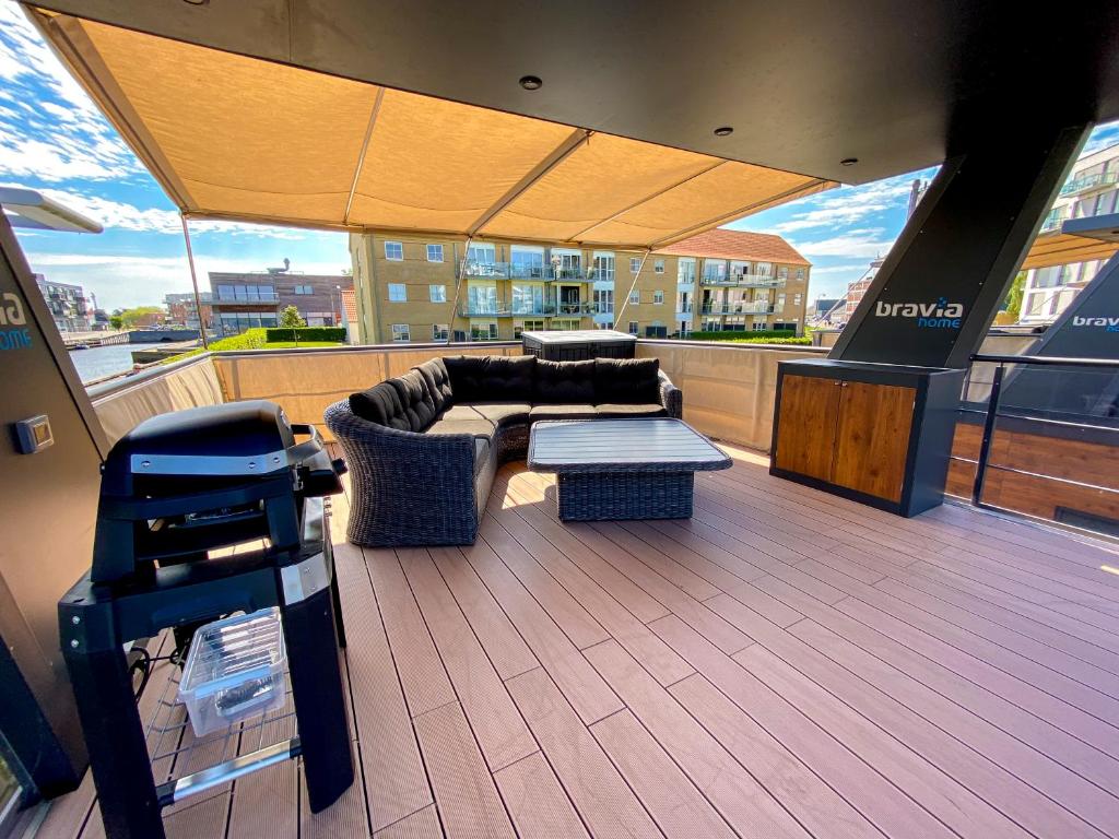 a balcony with a couch and a table on a boat at MarinaVilla in Nykøbing Falster