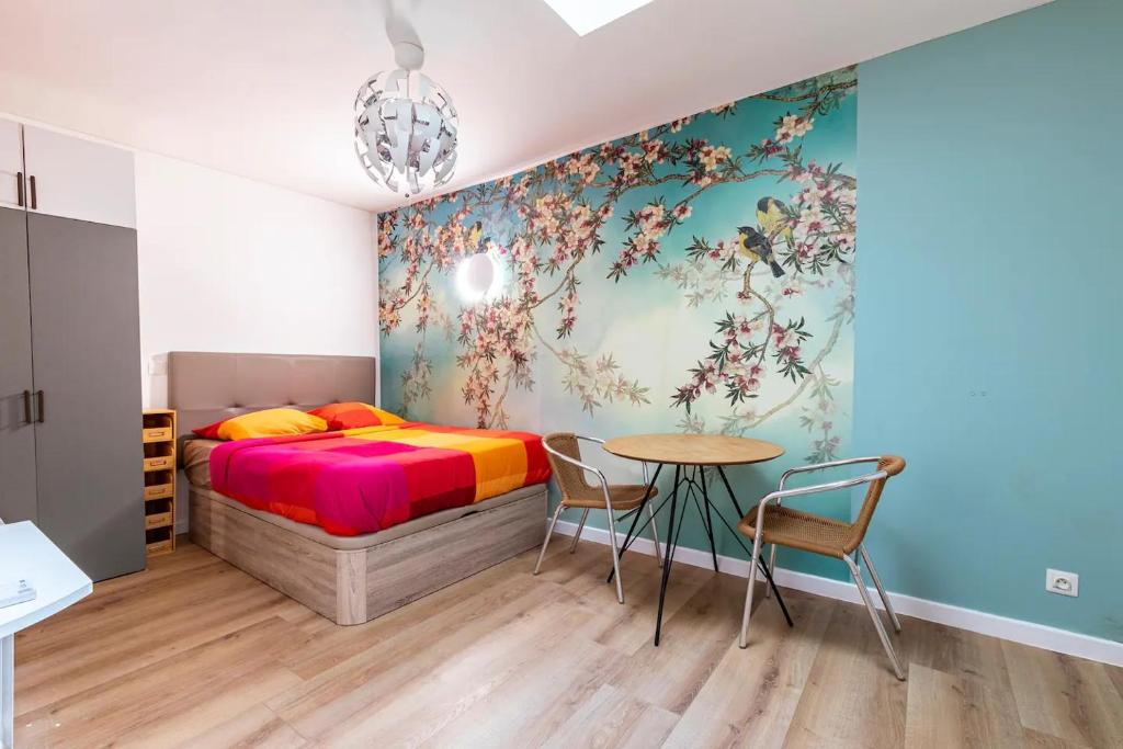 une chambre avec un lit, une table et des chaises dans l'établissement Gare du Nord Confortable pied à terre avec patio, à Paris