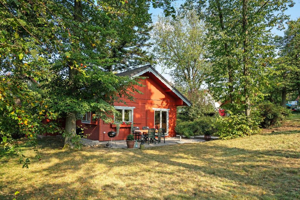 a small red house with a patio in a yard at Ferienhaus Moritzburg in Moritzburg