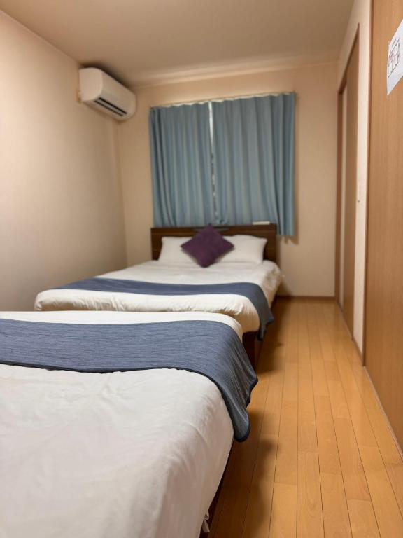 Postel nebo postele na pokoji v ubytování Comfy House Namba
