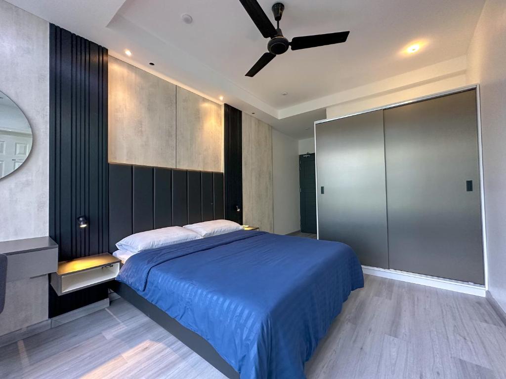 マレにあるModern, Cozy 2-Bedroom Apartmentのベッドルーム1室(青いベッド1台、天井ファン付)
