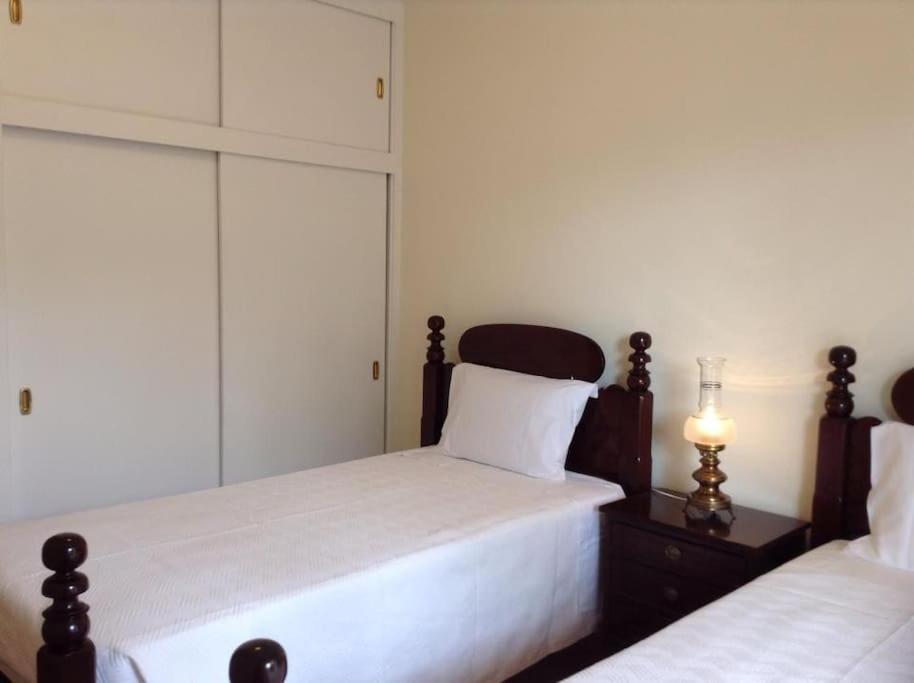 1 Schlafzimmer mit 2 Betten mit weißer Bettwäsche und einer Lampe in der Unterkunft Casa da Palmeira Porto Santo in Vila Baleira