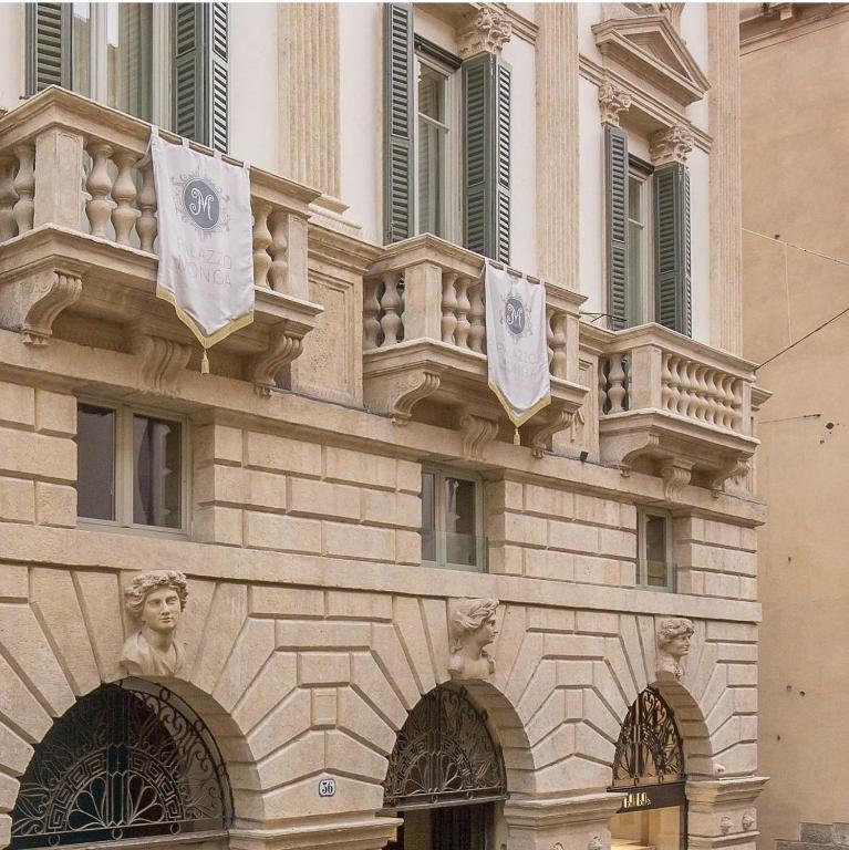 un bâtiment avec deux drapeaux sur son côté dans l'établissement The Ambassador Apartment by Palazzo Monga, à Vérone