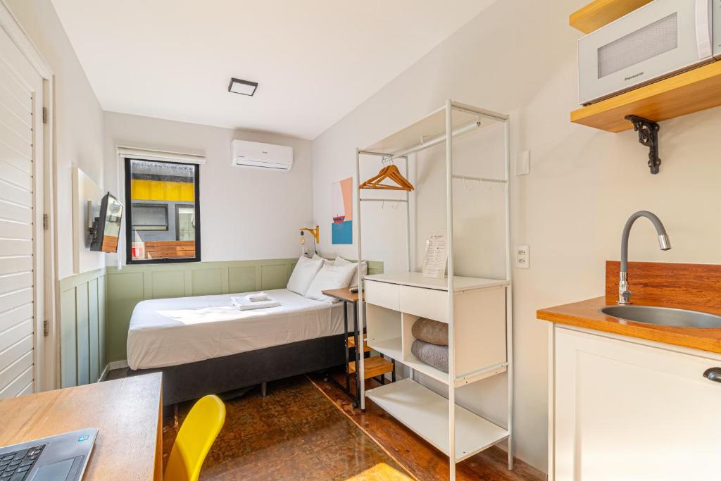 a small room with a bed and a sink at Casa Container-Piscina-AC-30min até Aeroporto in Florianópolis