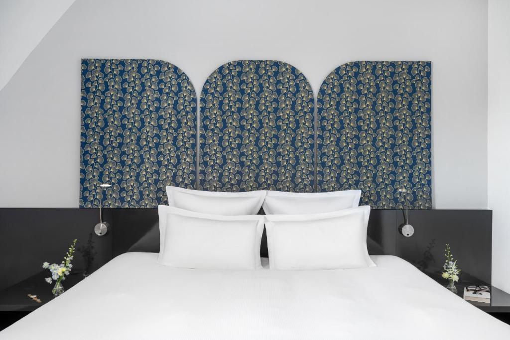 a bedroom with a bed with two white pillows at Nemzeti Hotel Budapest - MGallery Collection in Budapest