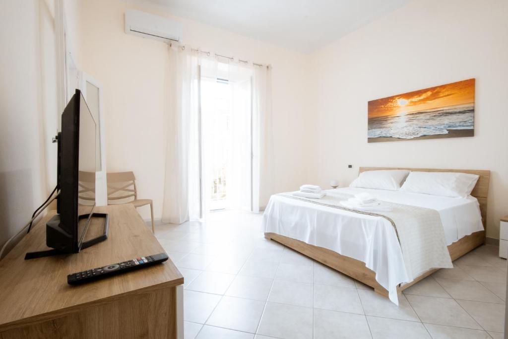 a bedroom with a bed and a flat screen tv at Krisà Apartment in Bari