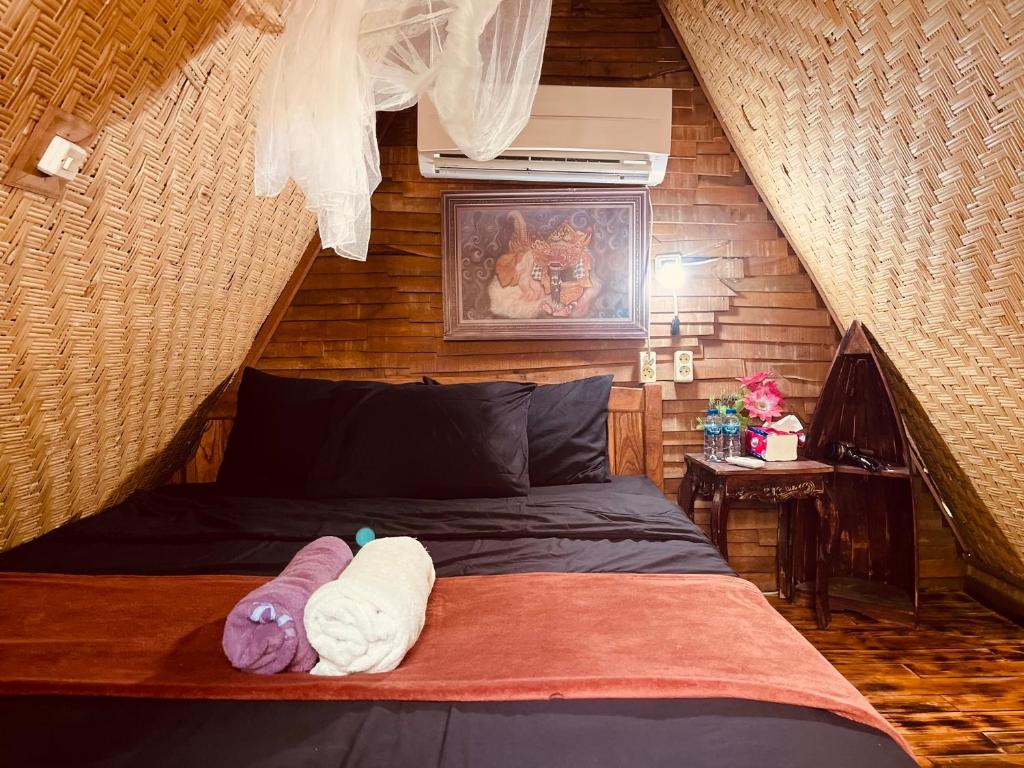 KintamaniにあるTriangle House and hot springのベッドルーム(ベッド1台、動物の詰め物付)