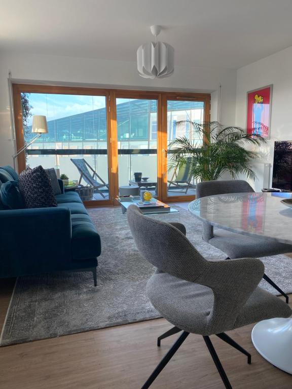 un salon avec une table en verre et des chaises dans l'établissement Fred Appartement Lille Centre, à Lille