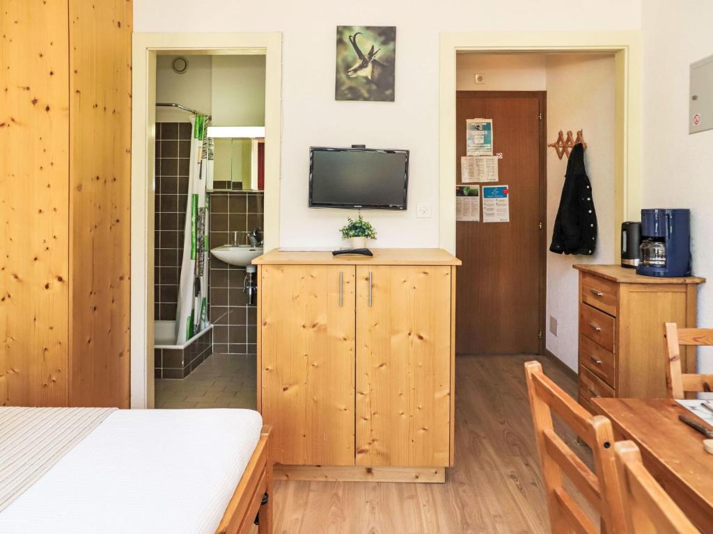 a bedroom with a bed and a tv and a bathroom at Apartment Rosablanche C22 by Interhome in Siviez