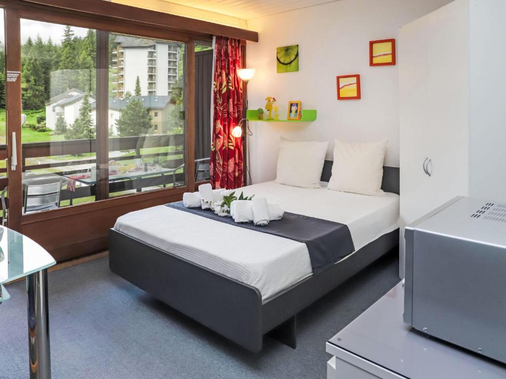 a bedroom with a bed and a large window at Apartment Rosablanche B22 by Interhome in Siviez