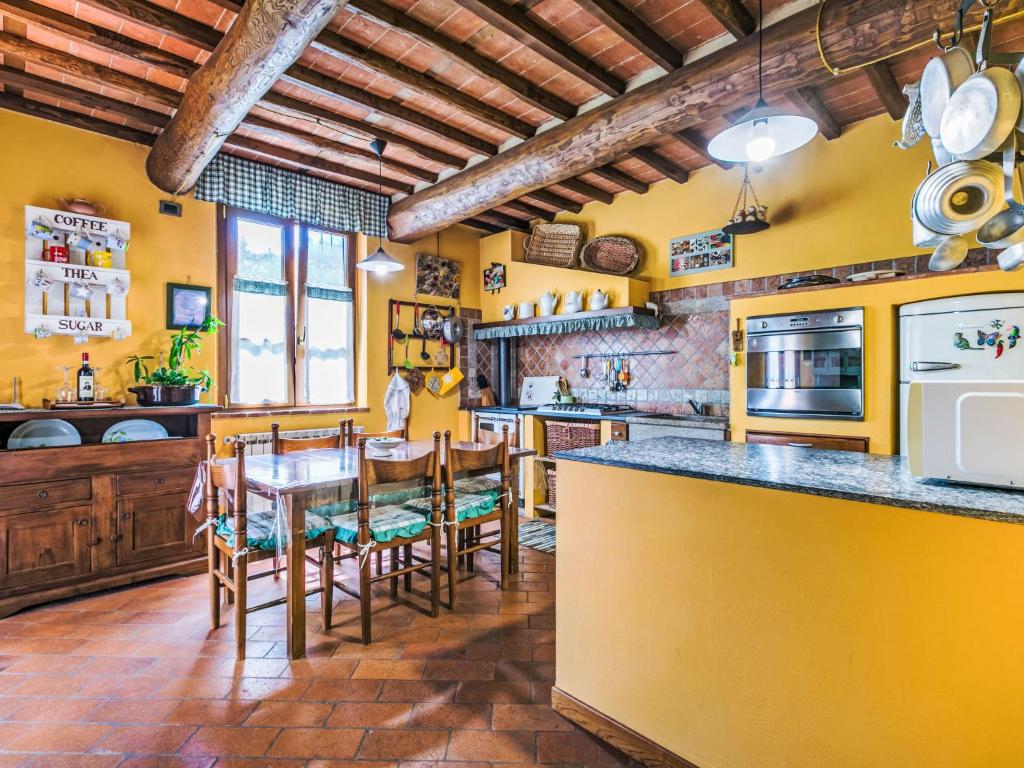 une cuisine avec des murs jaunes, une table et des chaises dans l'établissement Villa Luana by Interhome, à Ruota