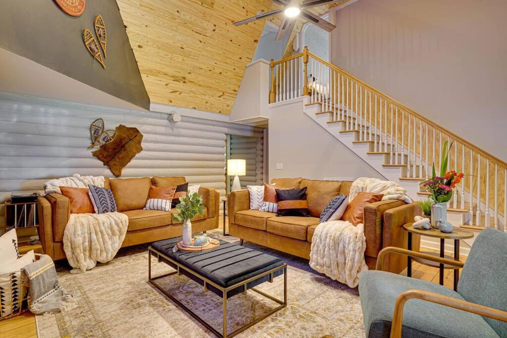 a living room with two couches and a staircase at Welcome to The Alpine Luxury Cabin in the City in Duluth
