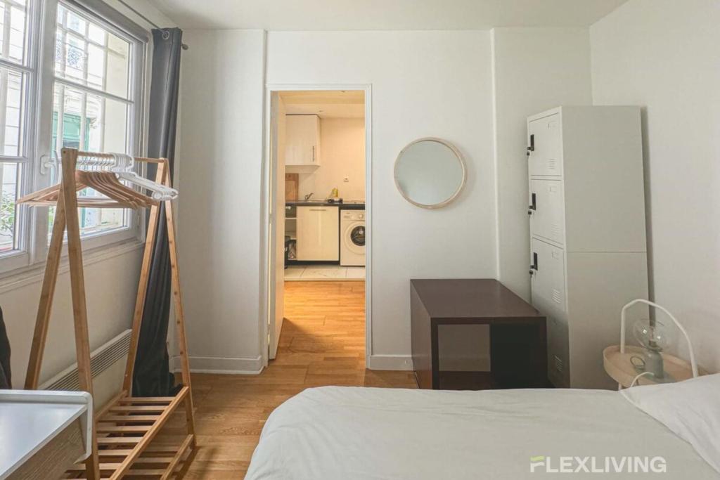 Cette chambre blanche dispose d'un lit et d'une cuisine. dans l'établissement Flexliving - room - Banquier, à Paris