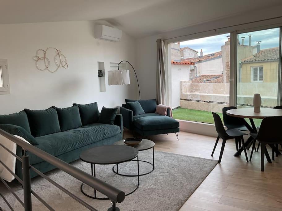 un salon avec un canapé vert et une table dans l'établissement Duplex rénové comme Neuf à Aix-en-Provence, à Aix-en-Provence