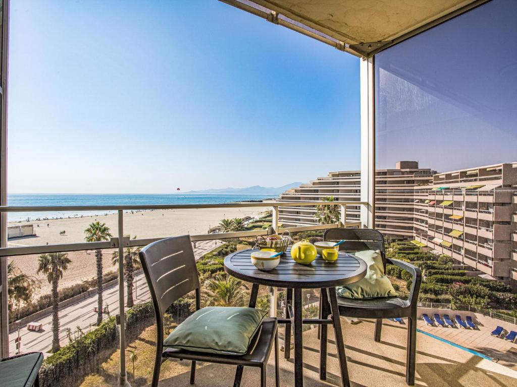 une table et des chaises sur un balcon avec vue sur la plage dans l'établissement Apartment Le Beach-26 by Interhome, à Canet