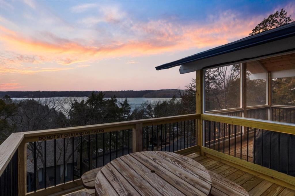 eine Terrasse mit Tisch und Blick aufs Wasser in der Unterkunft Paradise Lookout Margaritaville - Views and Pools in Osage Beach