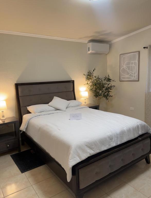 a bedroom with a large bed with white sheets at Hotel Mision Ferrer in San Vicente