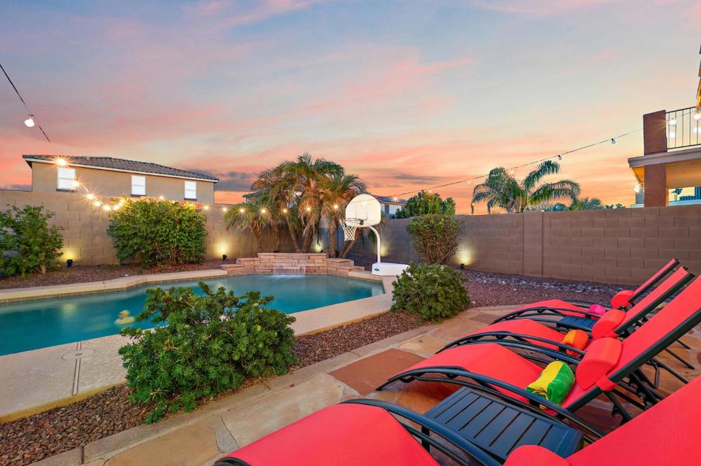 Un patio trasero con piscina y una casa. en The Gem Getaway Pool Gameroom Gym by Relaxtay, en Casa Grande