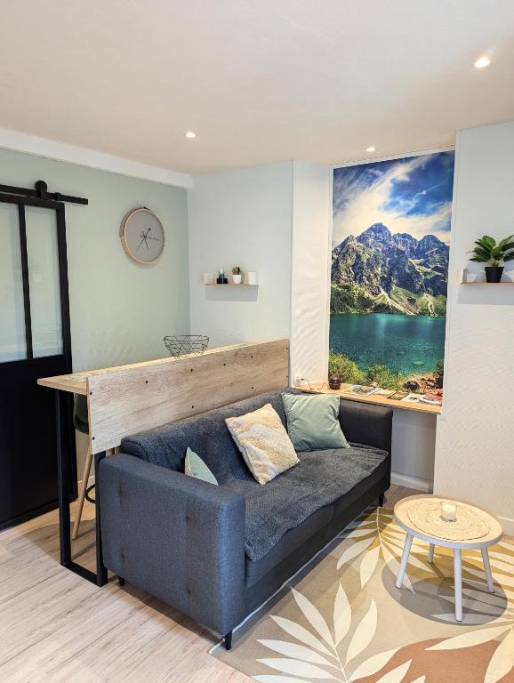 a living room with a couch and a large window at Appartement au cœur des Alpes in Albertville