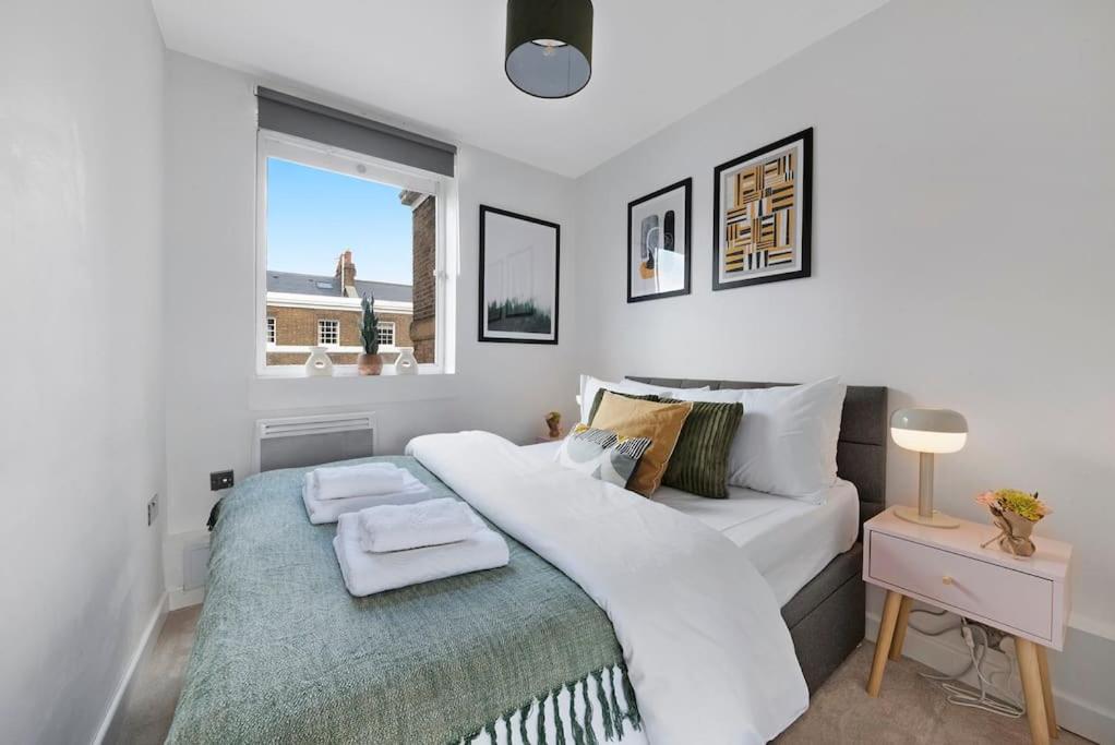 a bedroom with a large white bed and a window at Modern and Airy Belgravia Living in London
