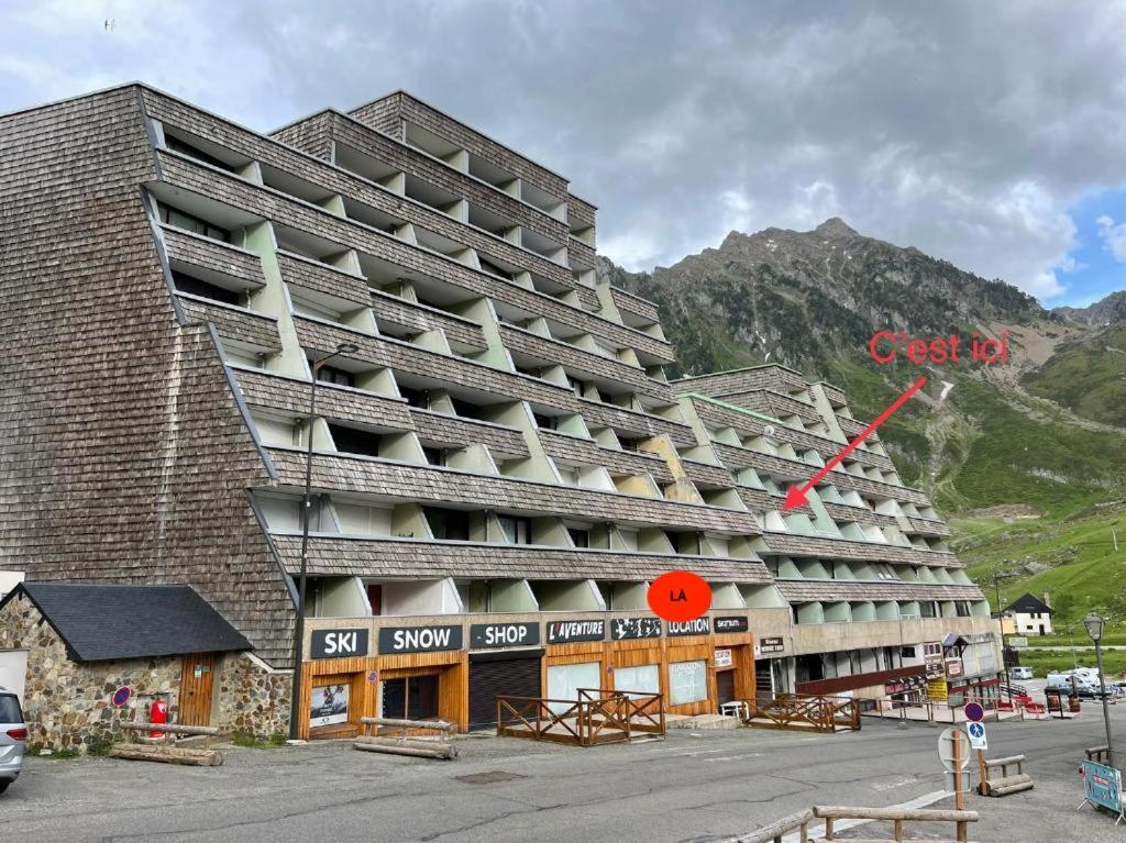 un grand immeuble en face d'une montagne dans l'établissement Appartement au pied des pistes, à La Mongie
