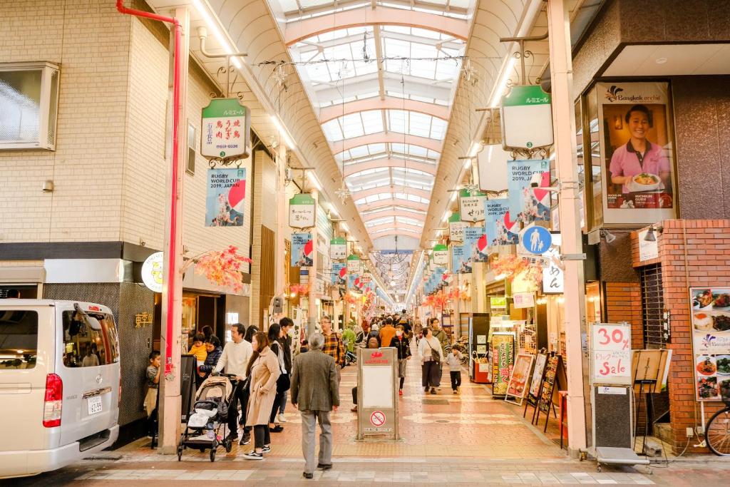 東京にあるNew Cozy APT Located on the Japanese Local shopping streetの商店街を歩く人々