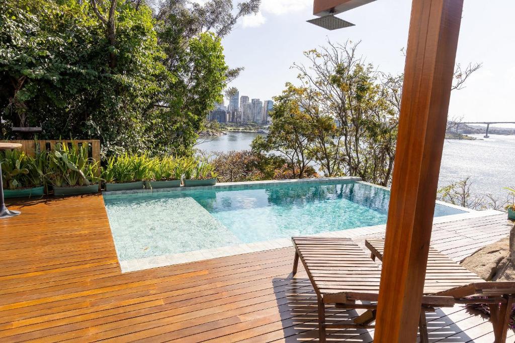 einen Pool auf einer Terrasse mit Blick auf das Wasser in der Unterkunft Casa LUXO c/ vista panorâmica em Vila Velha-SH095D in Convento da Penha