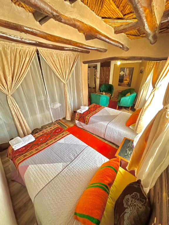 a group of three beds in a room at Kasbah El Hajja in Aït Benhaddou