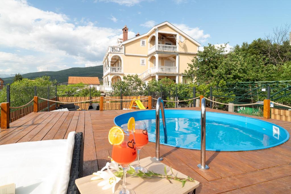 a swimming pool in front of a house at Adriatic Guest House Milić in Gornji Karin