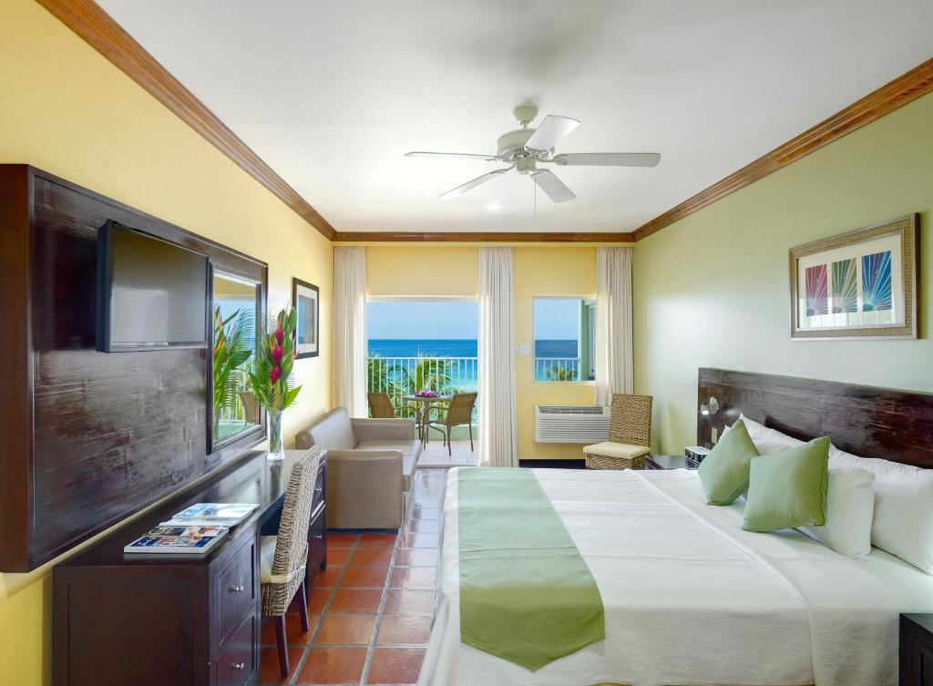 a hotel room with a bed and a television at Coconut Court Beach Hotel in Bridgetown