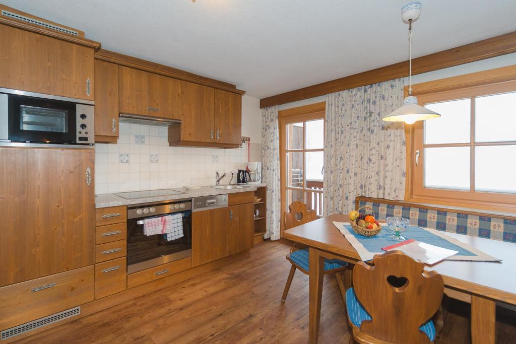 a kitchen with wooden cabinets and a wooden table with a tableablish at Glösalm in Ramsau am Dachstein