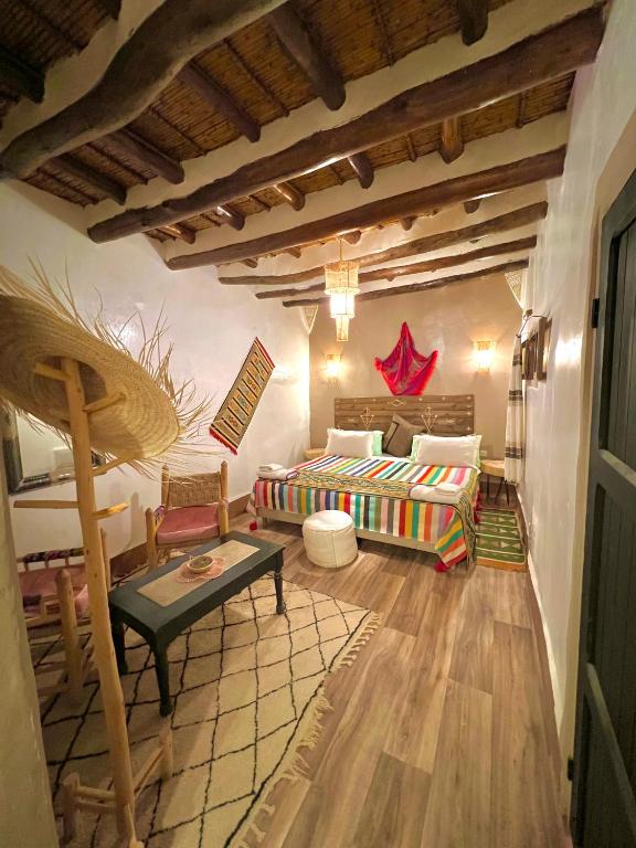 a living room with a bed and a table at Kasbah El Hajja in Aït Benhaddou