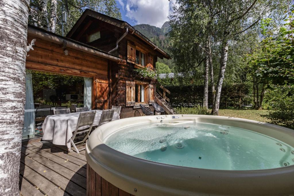 un jacuzzi en face d'une cabane en rondins dans l'établissement Mazot les Tines, à Chamonix-Mont-Blanc