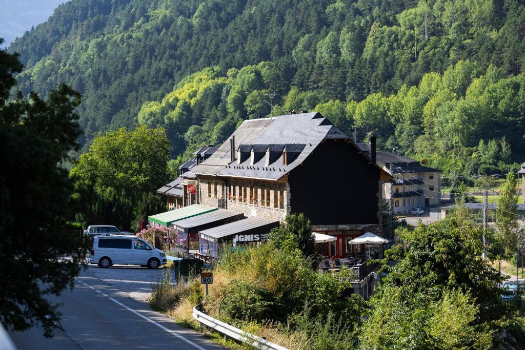 a building on the side of a road next to a mountain at Hostal Pañart in Bielsa