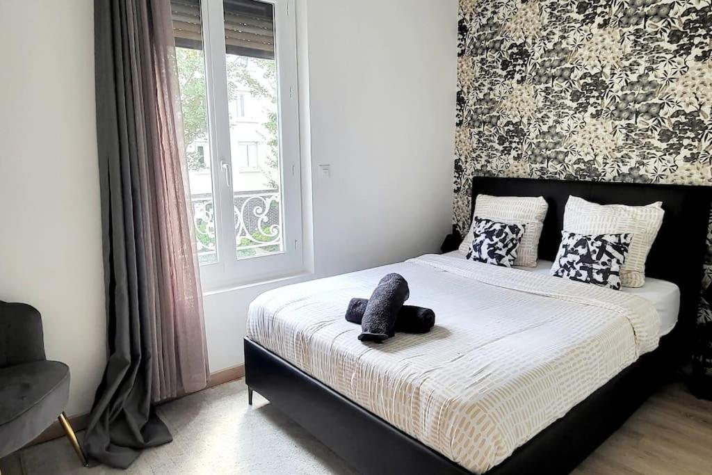 a bedroom with a bed with a stuffed animal on it at Le Premium, entre Paris & Disney avec Parking Gratuit in Noisy-le-Grand