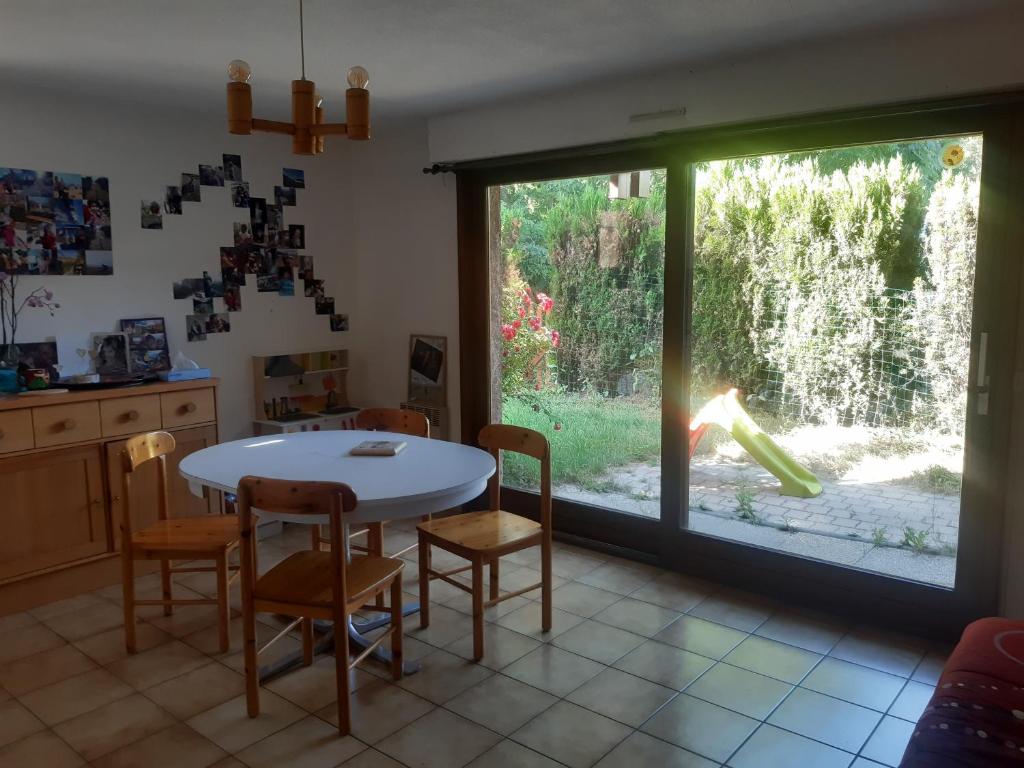 une cuisine avec une table et des chaises et une fenêtre dans l'établissement Appartement montagne, à Briançon